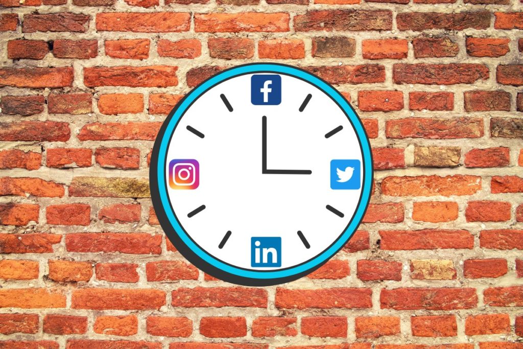 an analog clock hanging on a brick wall. At 12, 3, 6 and 9 are social media logos