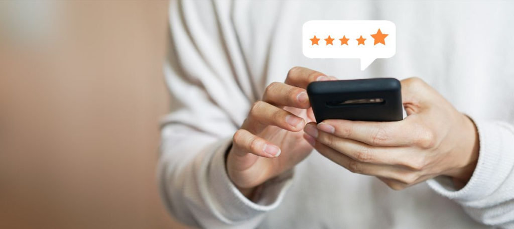 person holding a phone with a five star review above it